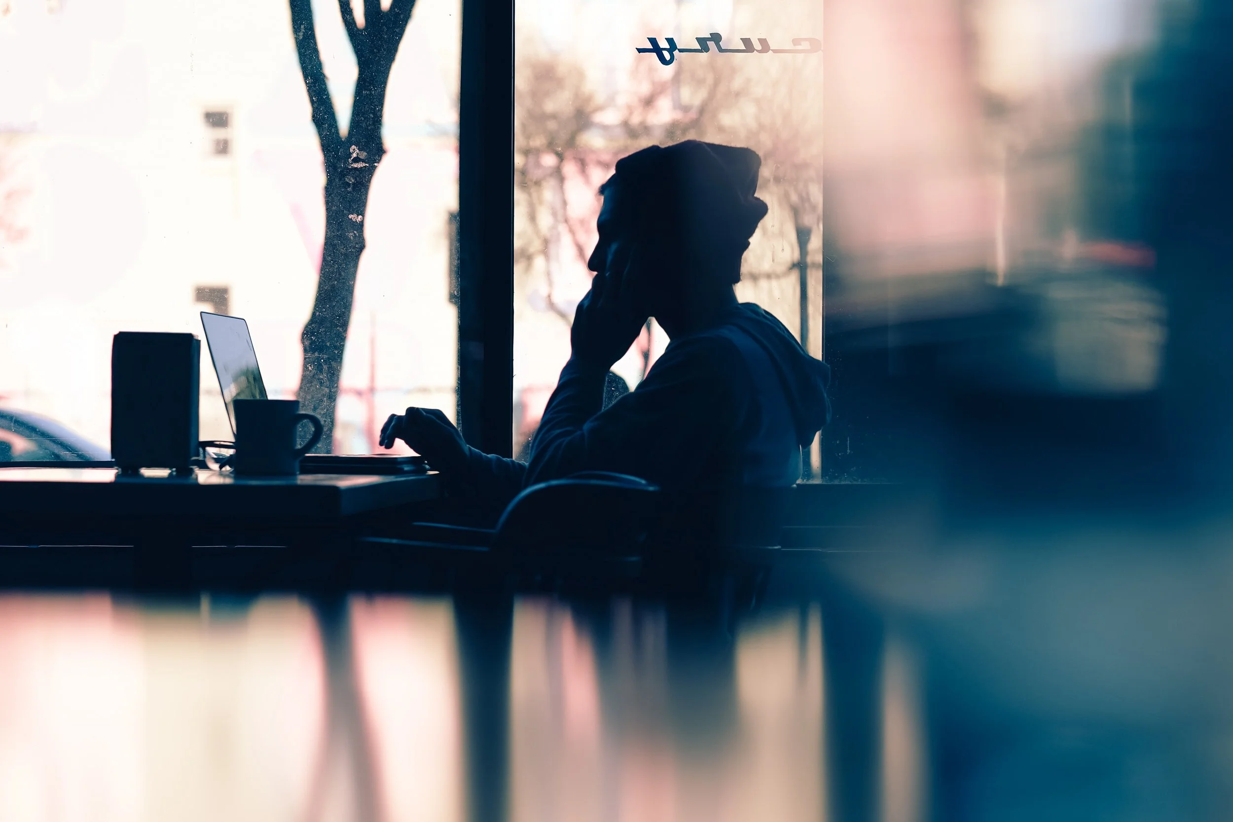 Person working at a laptop in a cafe