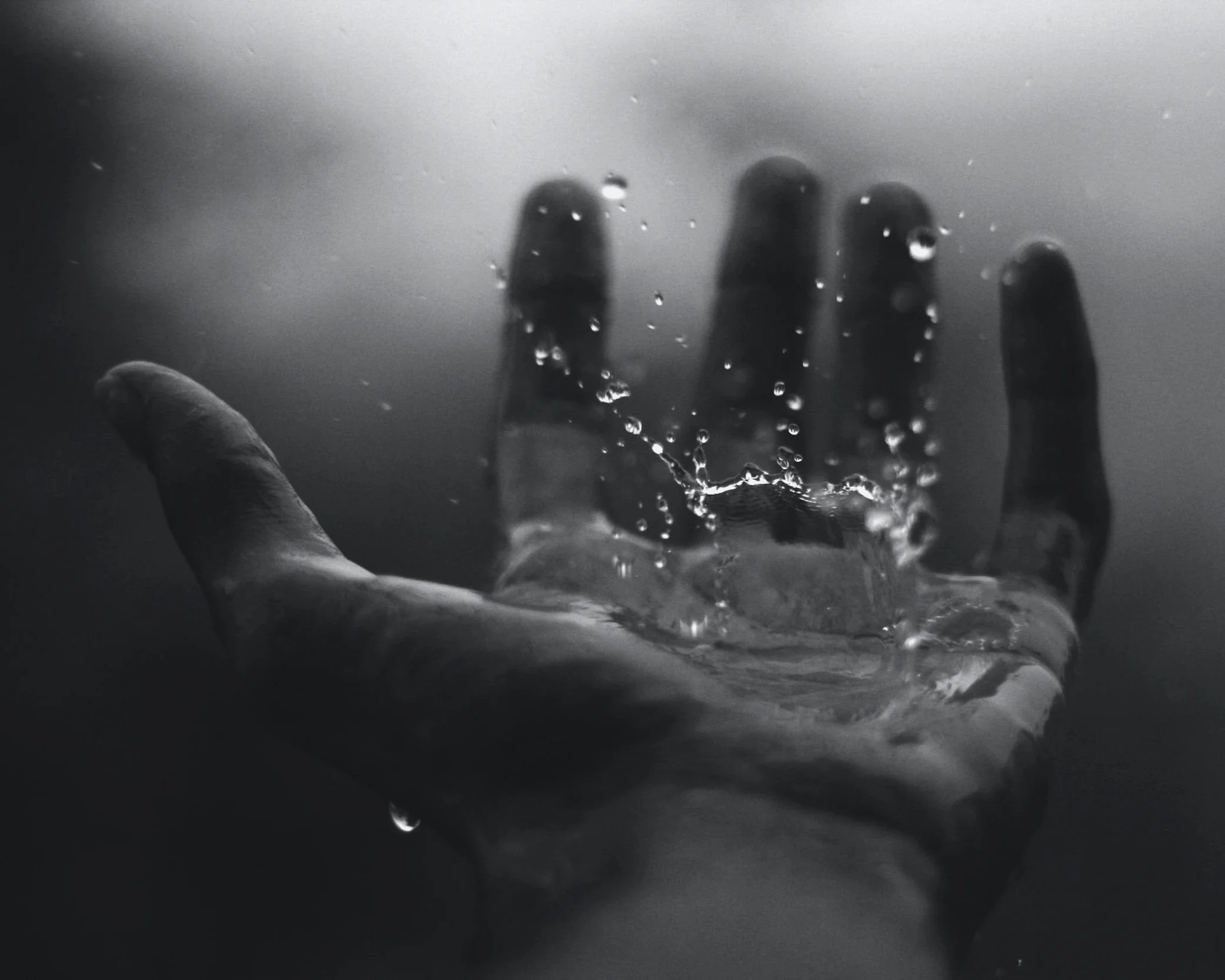 A hand outstretched in the rain