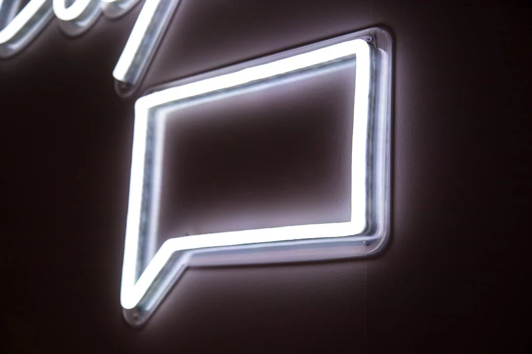 Neon speech bubble sign on a wall